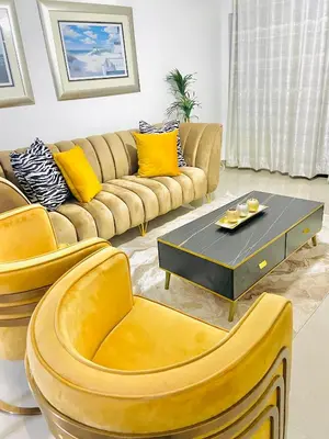 a living room with a couch and yellow chairs at The penthouse in Hartbeespoort