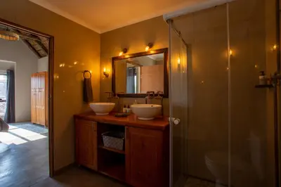 a bathroom with two sinks and a shower at Vuyani Marula Lodge in Hoedspruit