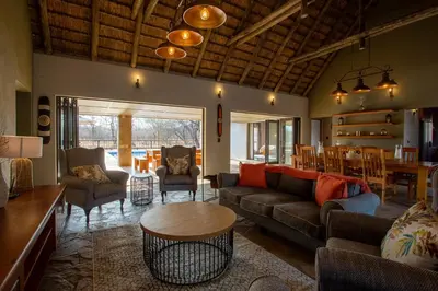 a living room with a couch and a table at Vuyani Marula Lodge in Hoedspruit
