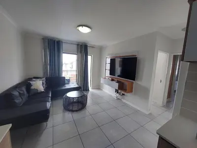 a living room with a couch and a television at The Blyde Penthouse in Pretoria