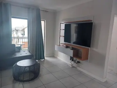 a living room with a flat screen tv on a wall at The Blyde Penthouse in Pretoria
