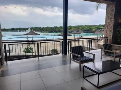 a balcony with chairs and a view of the water at The Blyde Penthouse in Pretoria