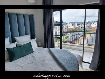 a bedroom with a bed and a large window at The Blyde Penthouse in Pretoria