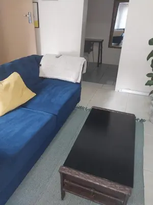 a blue couch in a living room with a table at Comfort place in Pretoria