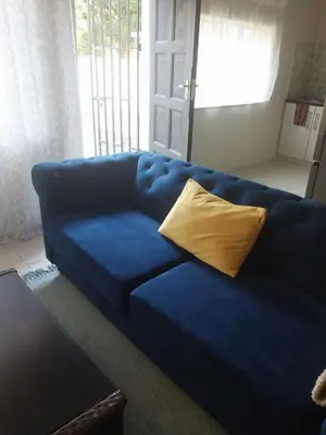 a blue couch with a yellow pillow in a living room at Comfort place in Pretoria
