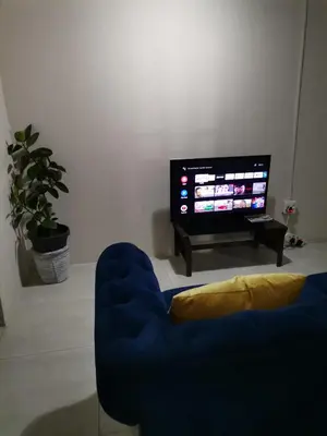 a living room with a blue couch and a tv at Comfort place in Pretoria