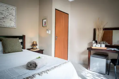 a bedroom with a bed and a wooden door at Bosveld Villa in Marloth Park