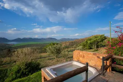 a hot tub on a hill with a view of the ocean at Koraalboom at Benlize in Hartbeespoort