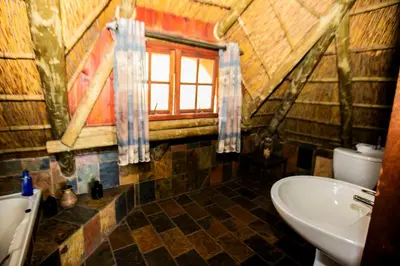 a bathroom with a sink and a toilet and a window at Koraalboom at Benlize in Hartbeespoort