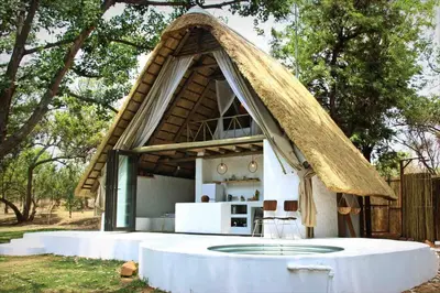 a small house with a thatched roof at Hot Spring bungalow in Limpopo in Gemsbokfontein