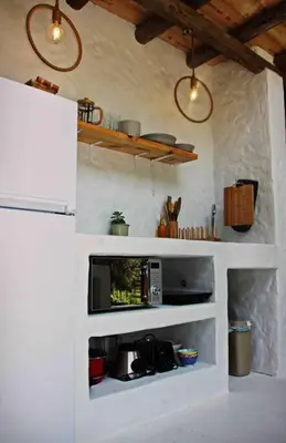 a kitchen with a tv in a white wall at Hot Spring bungalow in Limpopo in Gemsbokfontein