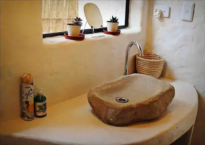a bathroom sink with a stone sink at Hot Spring bungalow in Limpopo in Gemsbokfontein
