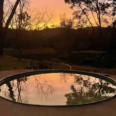 a reflection of the sunset in a pool of water at Hot Spring bungalow in Limpopo in Gemsbokfontein