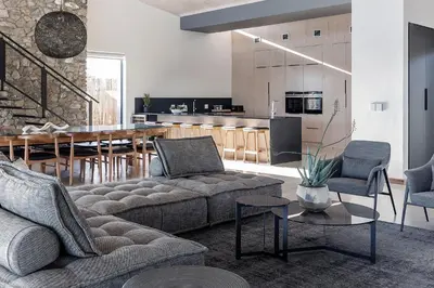 a living room with a couch and a kitchen at Maya Lodge in Hectorspruit
