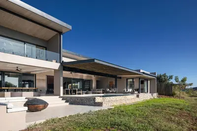 a modern house with a fireplace in a yard at Maya Lodge in Hectorspruit