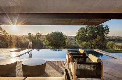 a person standing on the edge of a swimming pool at Maya Lodge in Hectorspruit
