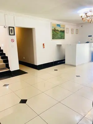 a room with a tile floor and a painting on the wall at Airport Royal Guest House in Kempton Park