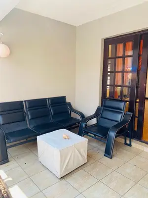 a living room with blue benches and a white table at Airport Royal Guest House in Kempton Park