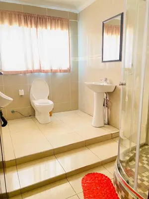 a bathroom with a toilet and a sink and a shower at Airport Royal Guest House in Kempton Park