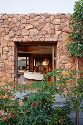 a stone building with a living room in the background at Matomo Safari Lodge in Welgevonden Game Reserve