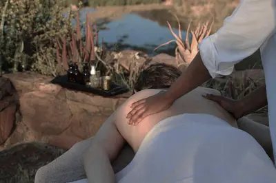 a man laying in a bath tub with a naked at Matomo Safari Lodge in Welgevonden Game Reserve