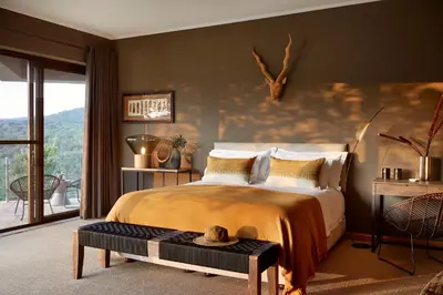 a bedroom with a large bed and a balcony at Matomo Safari Lodge in Welgevonden Game Reserve