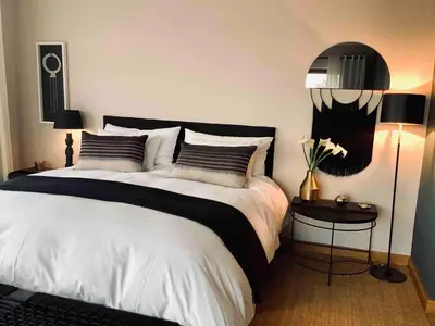 a bedroom with a large bed with two pillows and a lamp at Matomo Safari Lodge in Welgevonden Game Reserve