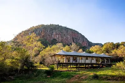 a large building with a mountain in the background at Mbizane Escarpment Retreat in Schoemanskloof