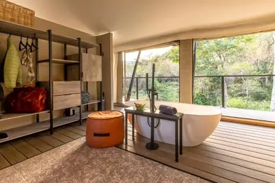 a bathroom with a large tub and a window at Mbizane Escarpment Retreat in Schoemanskloof