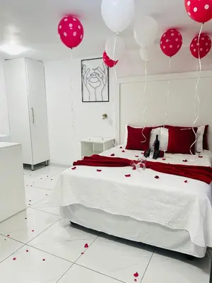 a bedroom with red and white balloons and a bed at Duvha Guesthouse in Graskop