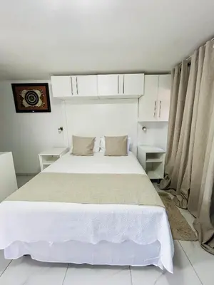 a bedroom with a large white bed with curtains at Duvha Guesthouse in Graskop