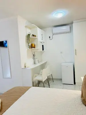 a white room with a bed and a table and chairs at Duvha Guesthouse in Graskop