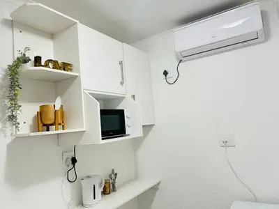 a bathroom with white cabinets and a tv on the wall at Duvha Guesthouse in Graskop