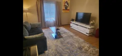 a living room with a couch and a flat screen tv at The Retreat, Midrand - 2bed 2bath in Midrand