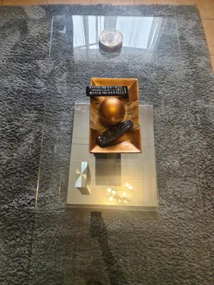 a glass table with two remote controls on it at The Retreat, Midrand - 2bed 2bath in Midrand