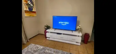 a tv sitting on a dresser in a living room at The Retreat, Midrand - 2bed 2bath in Midrand