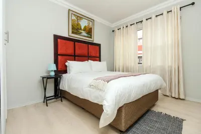 a white bedroom with a large bed and a window at Gorgeous Diamond in Midrand