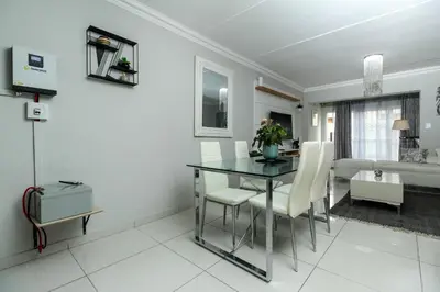 a dining room with a black table and white chairs at Gorgeous Diamond in Midrand