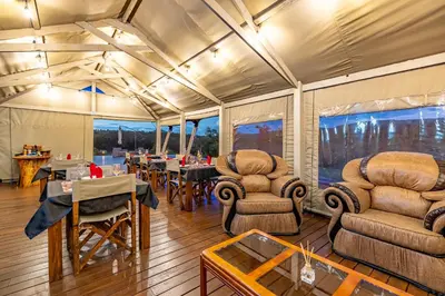 a dining area in a tent with tables and chairs at Iketla Lodge in Ohrigstad