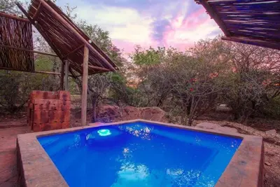 a large blue swimming pool sitting next to a house at Kaya KaBush in Marloth Park