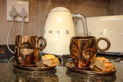 two coffee mugs on a counter next to a toaster at Kaya KaBush in Marloth Park