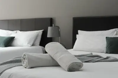 a pair of beds with towels on them at Magnolia Hotel in Middelburg