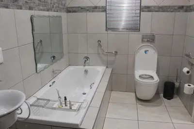 a bathroom with a tub and a toilet and a sink at Magnolia Hotel in Middelburg