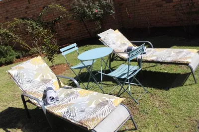 three chairs and a table and a table and chairs at Magnolia Hotel in Middelburg