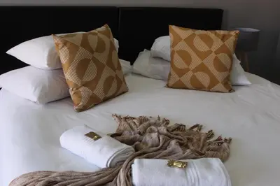 a white bed with pillows and towels on it at Magnolia Hotel in Middelburg