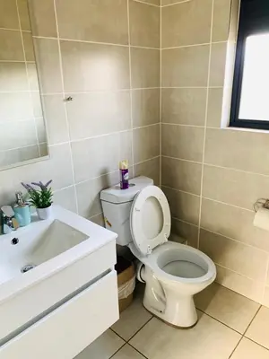 a bathroom with a toilet and a sink at The blyde-Luxury one bedroom apartment in Pretoria