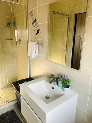 a bathroom with a white sink and a mirror at The blyde-Luxury one bedroom apartment in Pretoria