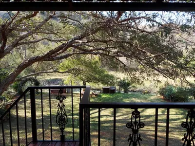 a balcony with a view of a yard at Aloes Country Inn in Waterval Boven