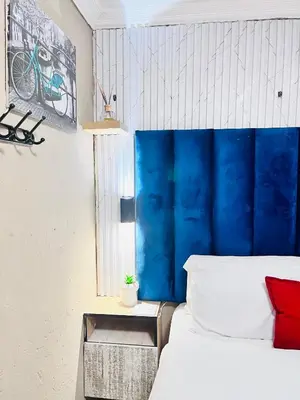 a bedroom with a blue headboard and a bed at Executive Galaxy Guest House Nkowankowa in Nkowakowa