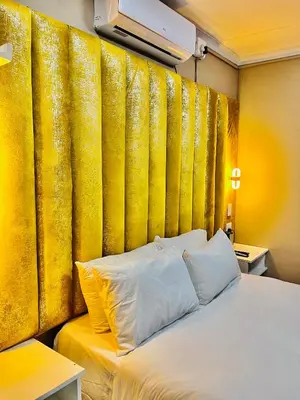 a bed in a room with a yellow wall at Executive Galaxy Guest House Nkowankowa in Nkowakowa